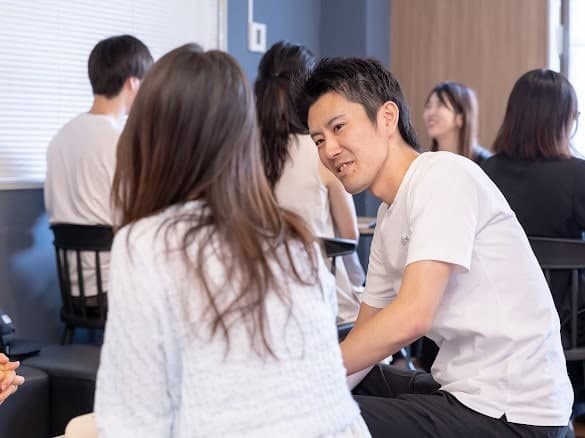 テーブルを挟んで、静かに話し込んでいる参加者